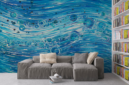 Gray sectional sofa in front of a blue abstract wall mural with a bookshelf to the right. 1420 Water Flow by Doug LaRue