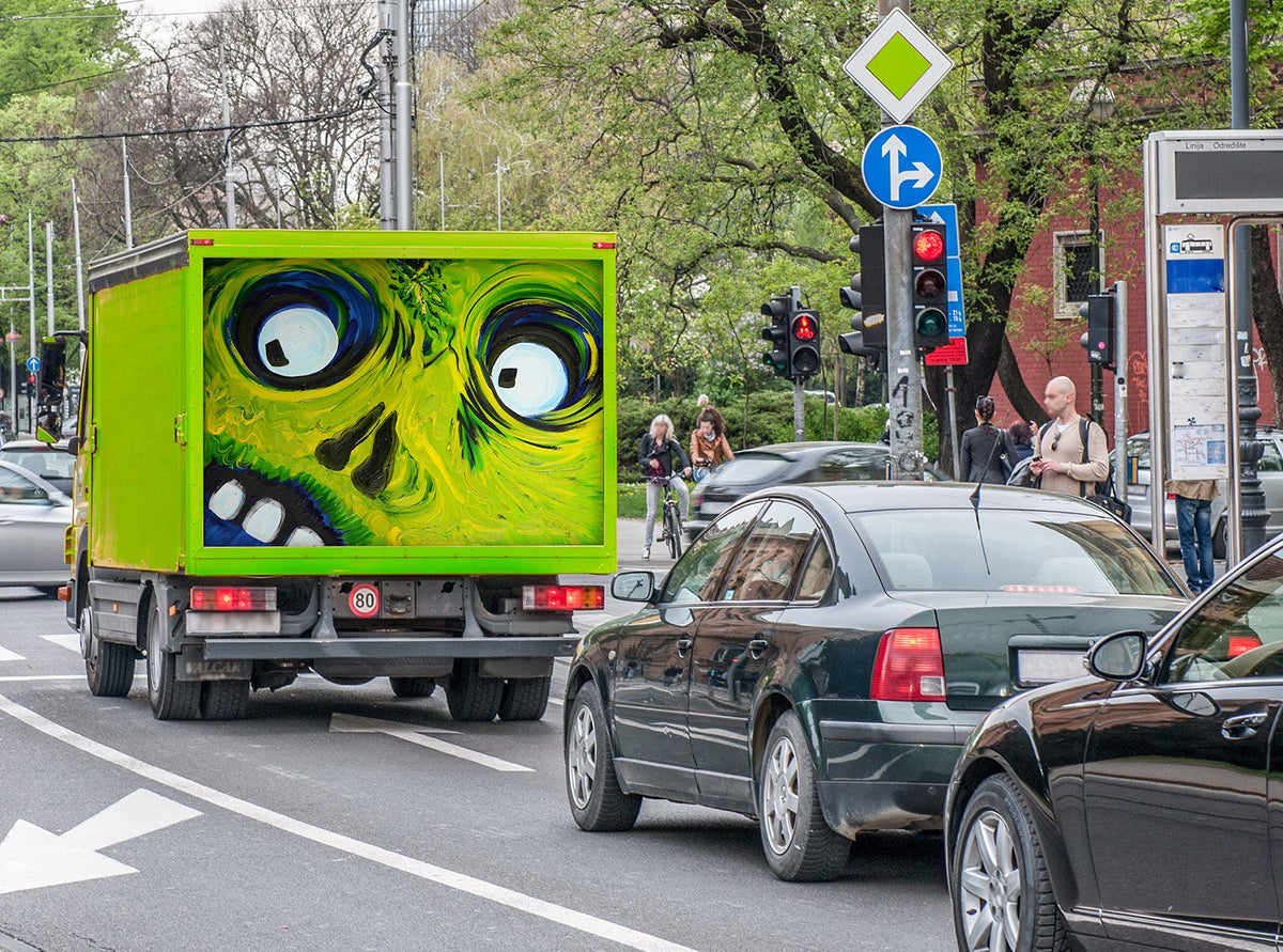Green truck with Crazy Eyes oil painting on the cargo door in heavy traffic on a city street