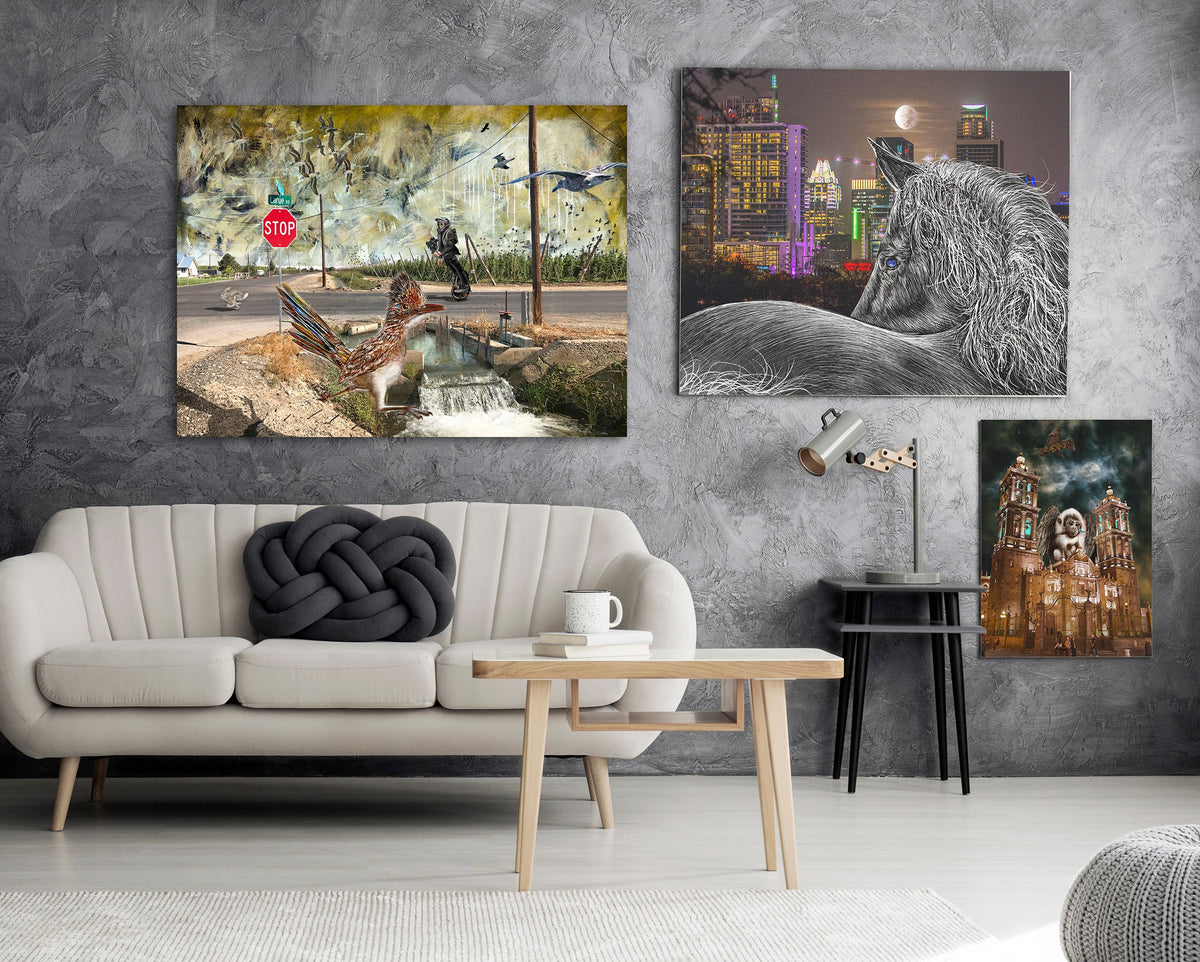 Three vertical canvas wall art prints displayed on a textured dark gray wall above a modern white sofa in a styled living room.
