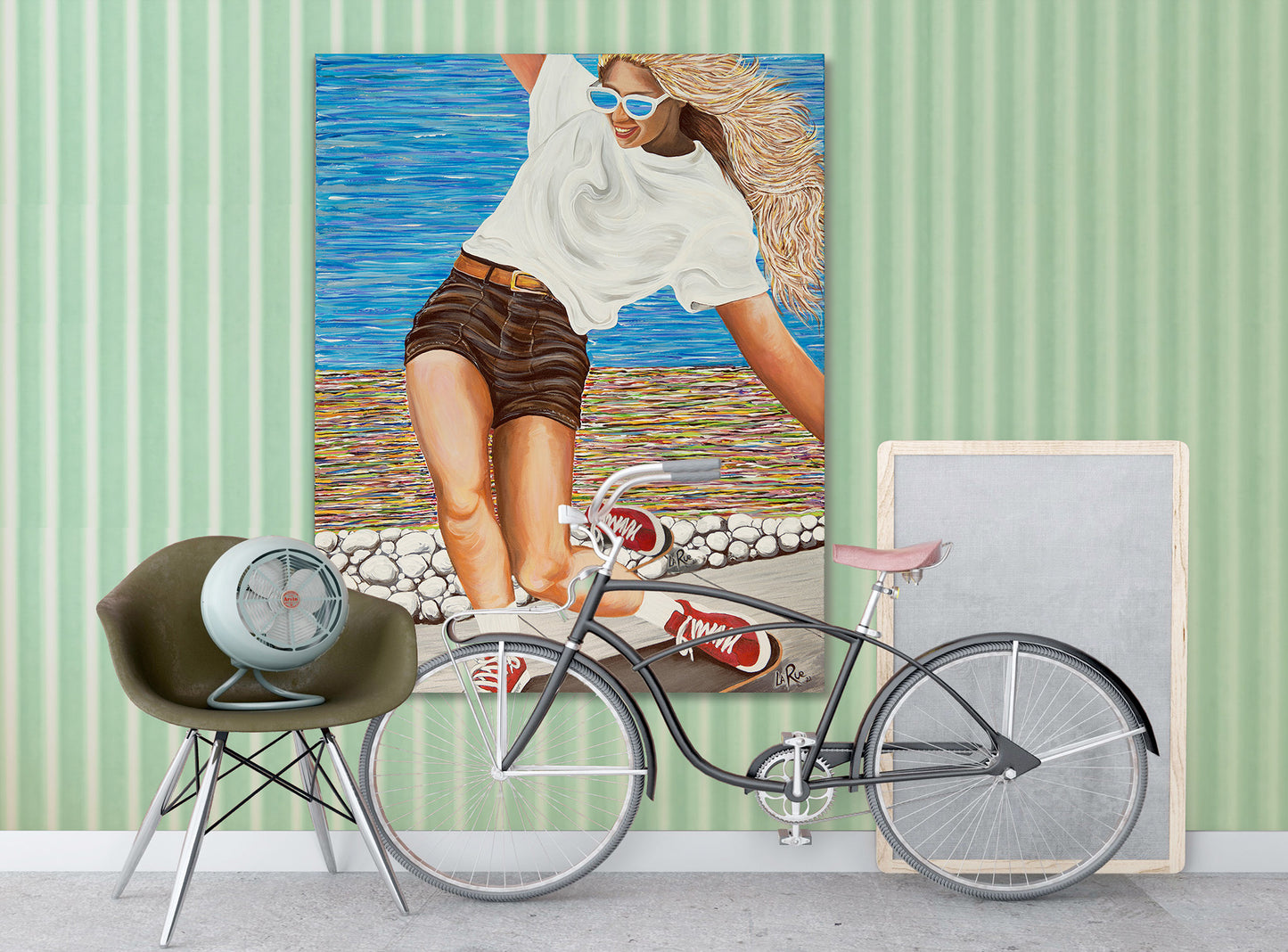 SK8 Girls Like You acrylic painting by Doug LaRue • Woman skateboarding on a wooden deck with a colorful abstract oceanside beach path.Bicycle in front of a painting of a woman on a beach with a green striped wall.