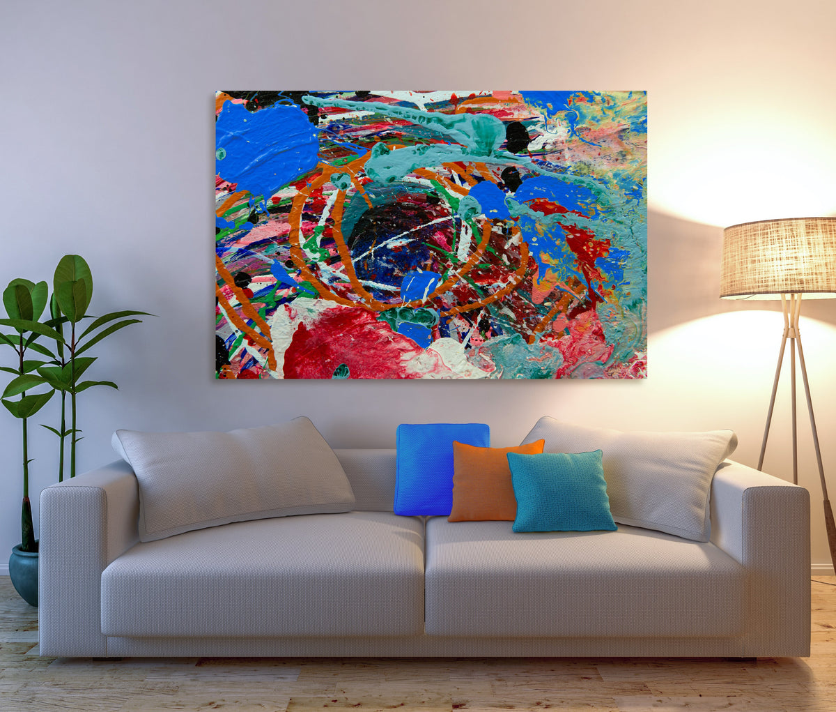 A colorful abstract canvas painting with vibrant blue, red, orange, and green brushstrokes, displayed on a white wall above a modern white sofa with decorative throw pillows in a styled living room setting. Sweetbriar Deep Ellem b y Doug LaRue