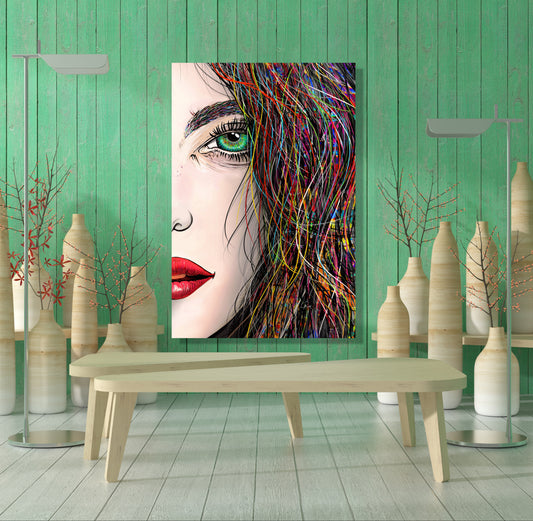 A vertical canvas art print featuring a stylized close-up portrait of a woman with green eyes, red lips, and colorful hair, displayed on a mint green wooden wall above a light wood bench in a modern styled room. Tara's Green Eye by our LaRue