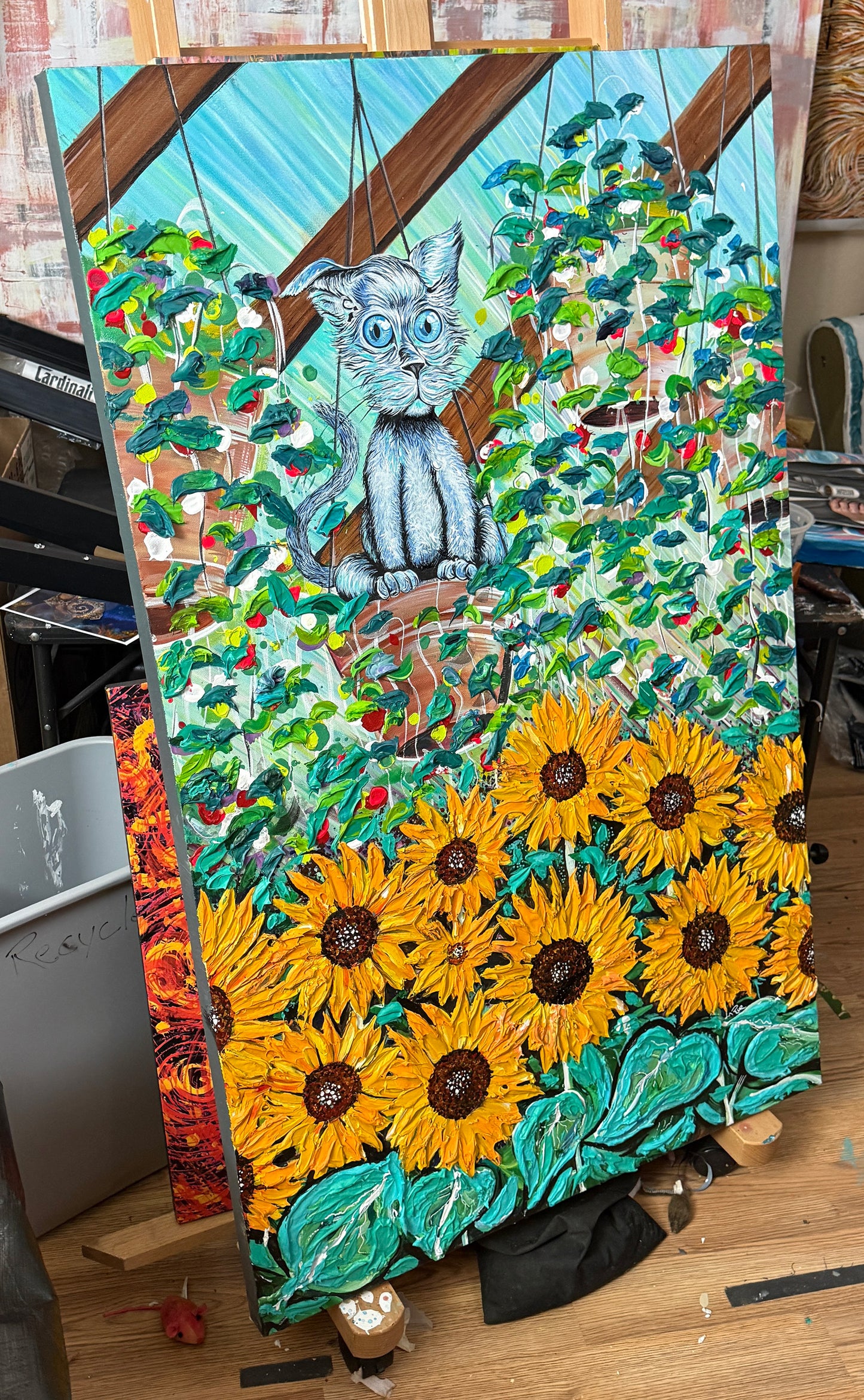 Colorful painting of a cat and sunflowers on an easel Green House Hang Out by Doug LaRue
