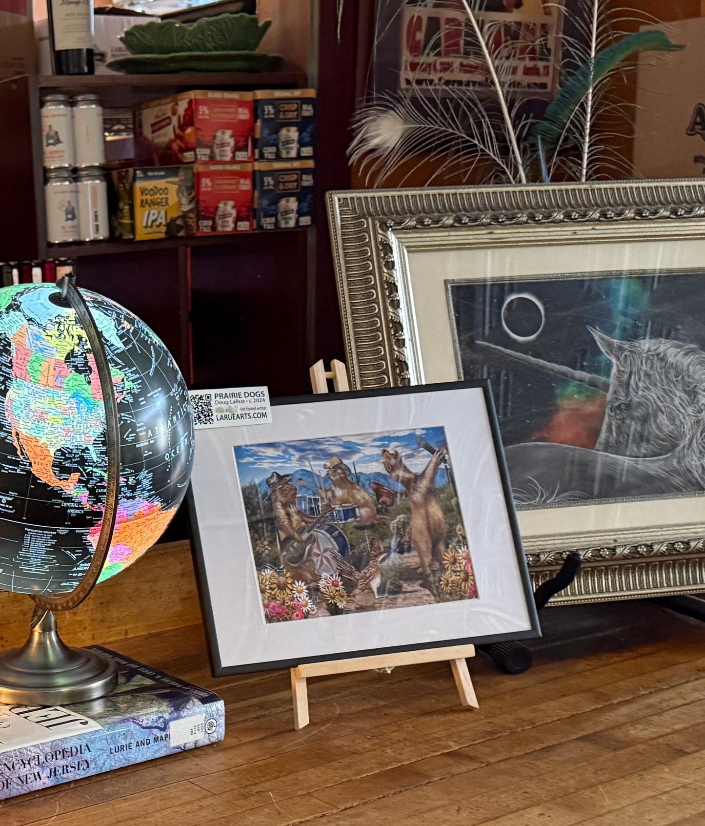 The Prairie Dogs Spring 11x14x1 black metal frame on the bar at NeWorlDeli