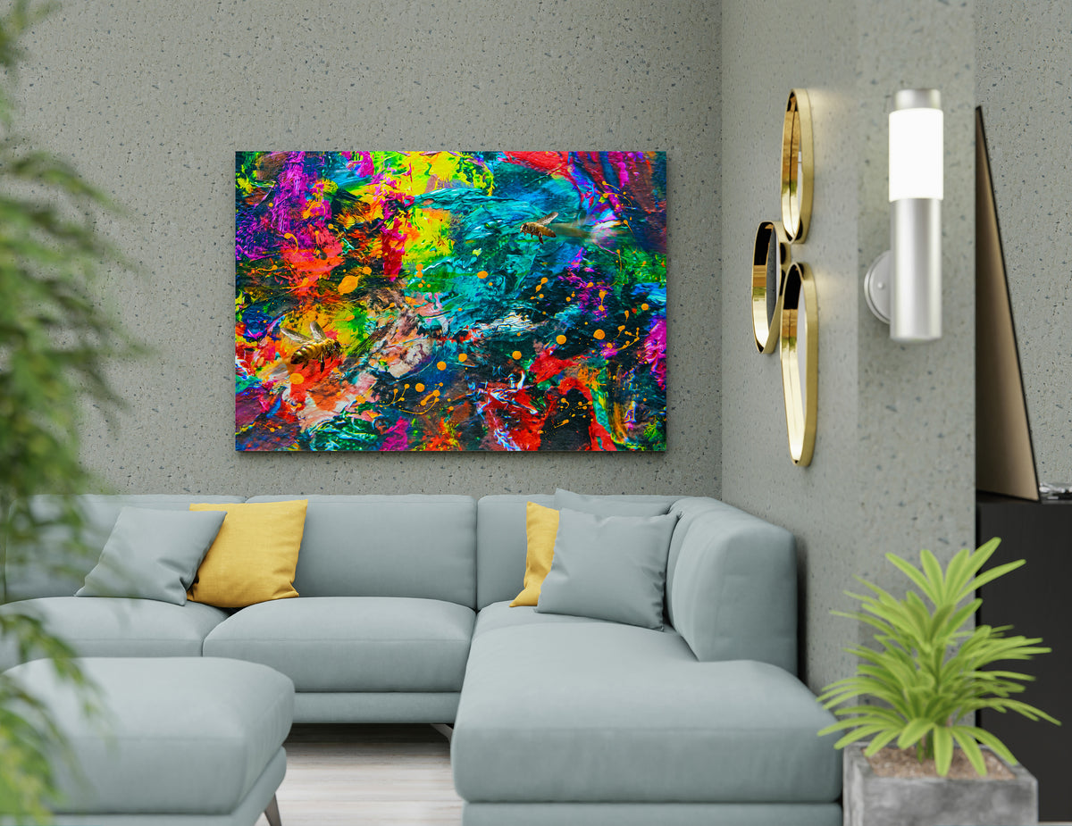 A colorful abstract canvas wall art print featuring vibrant splatters of red, yellow, green, blue, and purple, displayed in a modern living room setting above a light blue sectional sofa. Bee Caves abstract mixed media by Doug LaRue