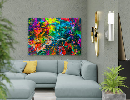 A colorful abstract canvas wall art print featuring vibrant splatters of red, yellow, green, blue, and purple, displayed in a modern living room setting above a light blue sectional sofa. Bee Caves abstract mixed media by Doug LaRue