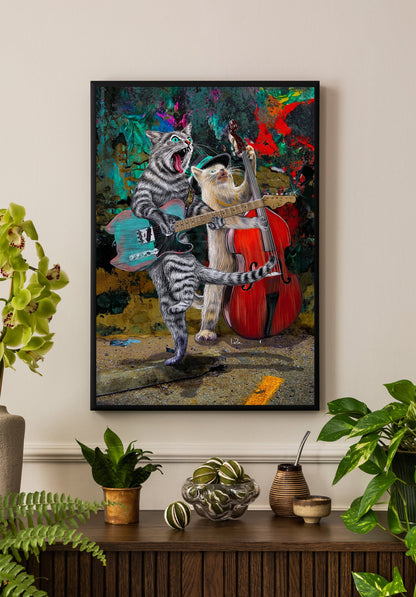 A framed colorful art print depicting two anthropomorphic cats playing music, hanging on a beige wall above a wooden console table with potted plants and decorative items.