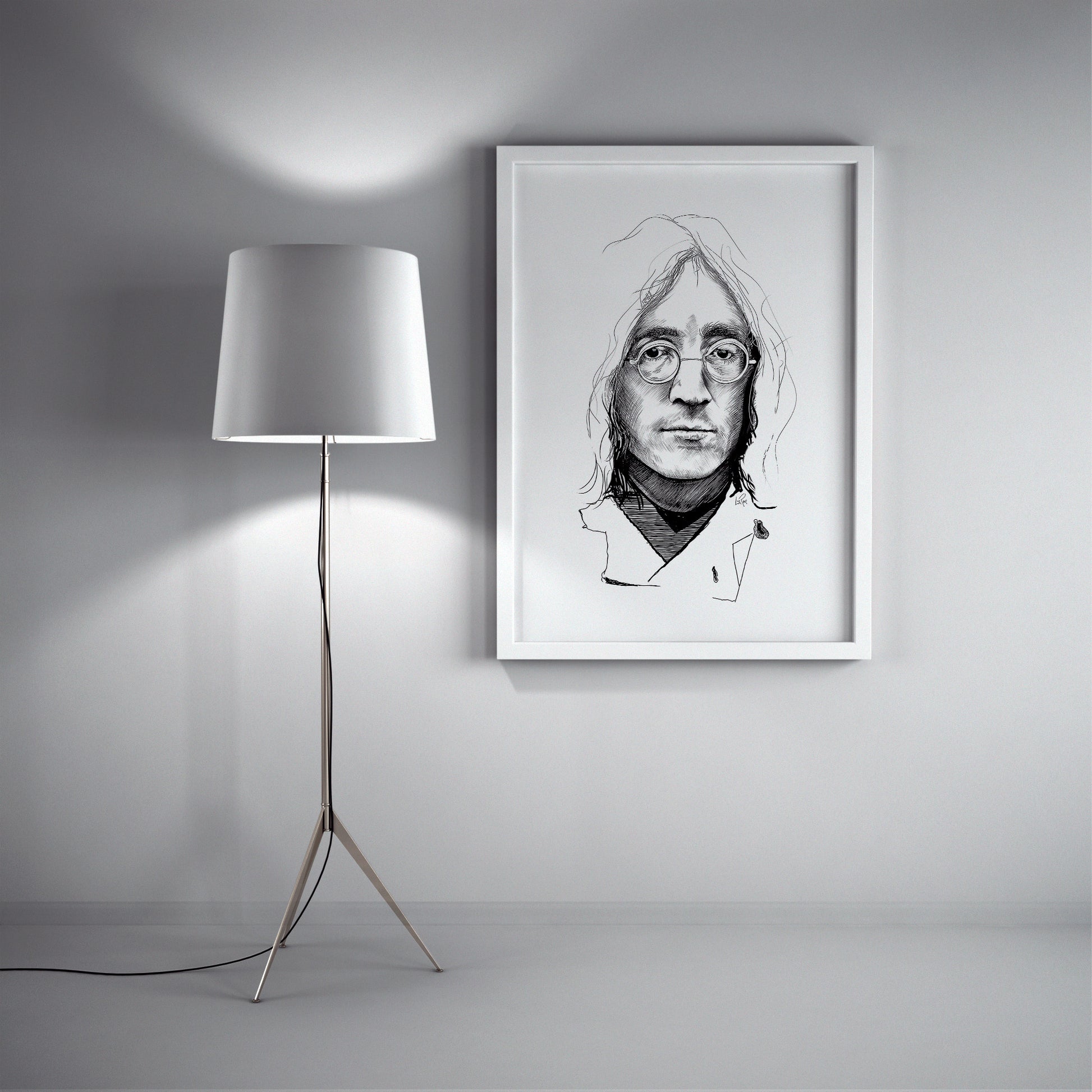 Framed black and white portrait of a person with glasses on a wall next to a floor lamp. John Lennon sketch by Doug LaRue