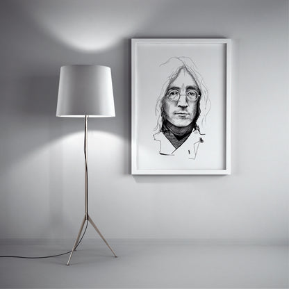 Framed black and white portrait of a person with glasses on a wall next to a floor lamp. John Lennon sketch by Doug LaRue