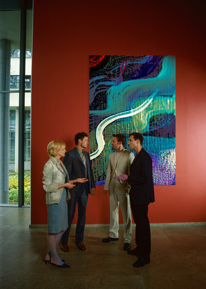 Four people standing and discussing a large abstract painting on a red wall in a gallery or museum setting.