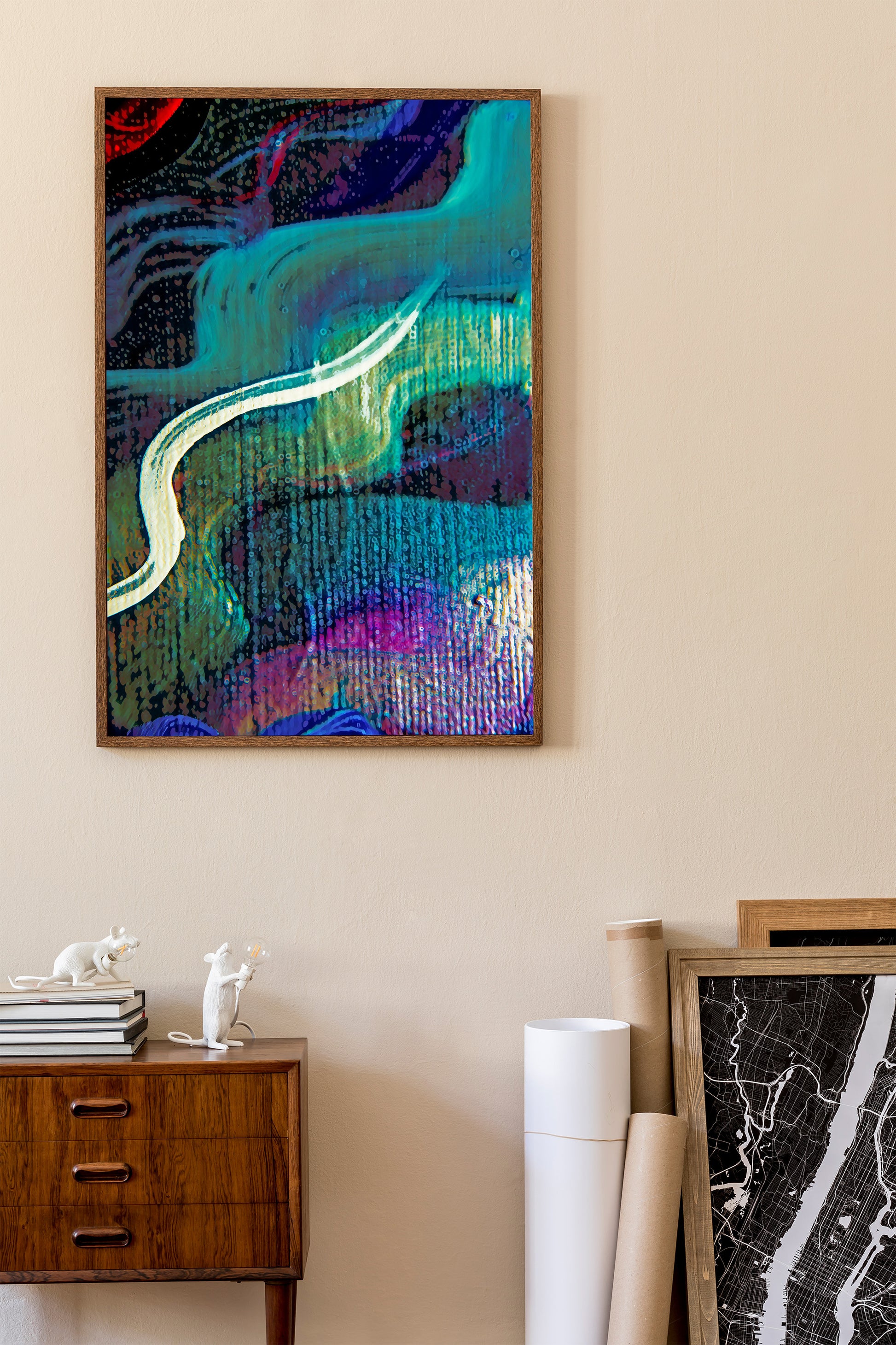 An abstract framed painting with swirling teal, purple, blue, black, and white brushstrokes hanging on a beige wall above a wooden sideboard in a styled interior setting.  Lost Creek art by Doug LaRue