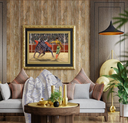 A framed bullfighting art print hangs on a rustic wood-paneled wall above a modern gray sofa with patterned pillows in a styled living room. Matador e Toro by Doug LaRue