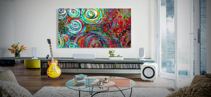 Living room with a colorful abstract painting on the wall, guitar, and glass coffee table.  Millwood Drumkit by Doug LaRue