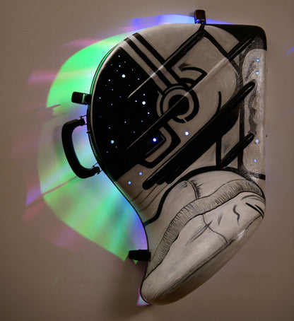 A hand-painted French horn case in the form of an astronauts helmet. Space Helmet with glowing LED party lights mounted inside to glow through hols in the helmet screen