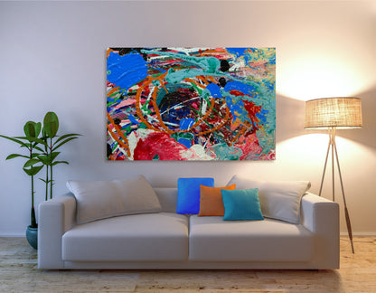 A colorful abstract canvas painting with vibrant blue, red, orange, and green brushstrokes, displayed on a white wall above a modern white sofa with decorative throw pillows in a styled living room setting. Sweetbriar Deep Ellem b y Doug LaRue