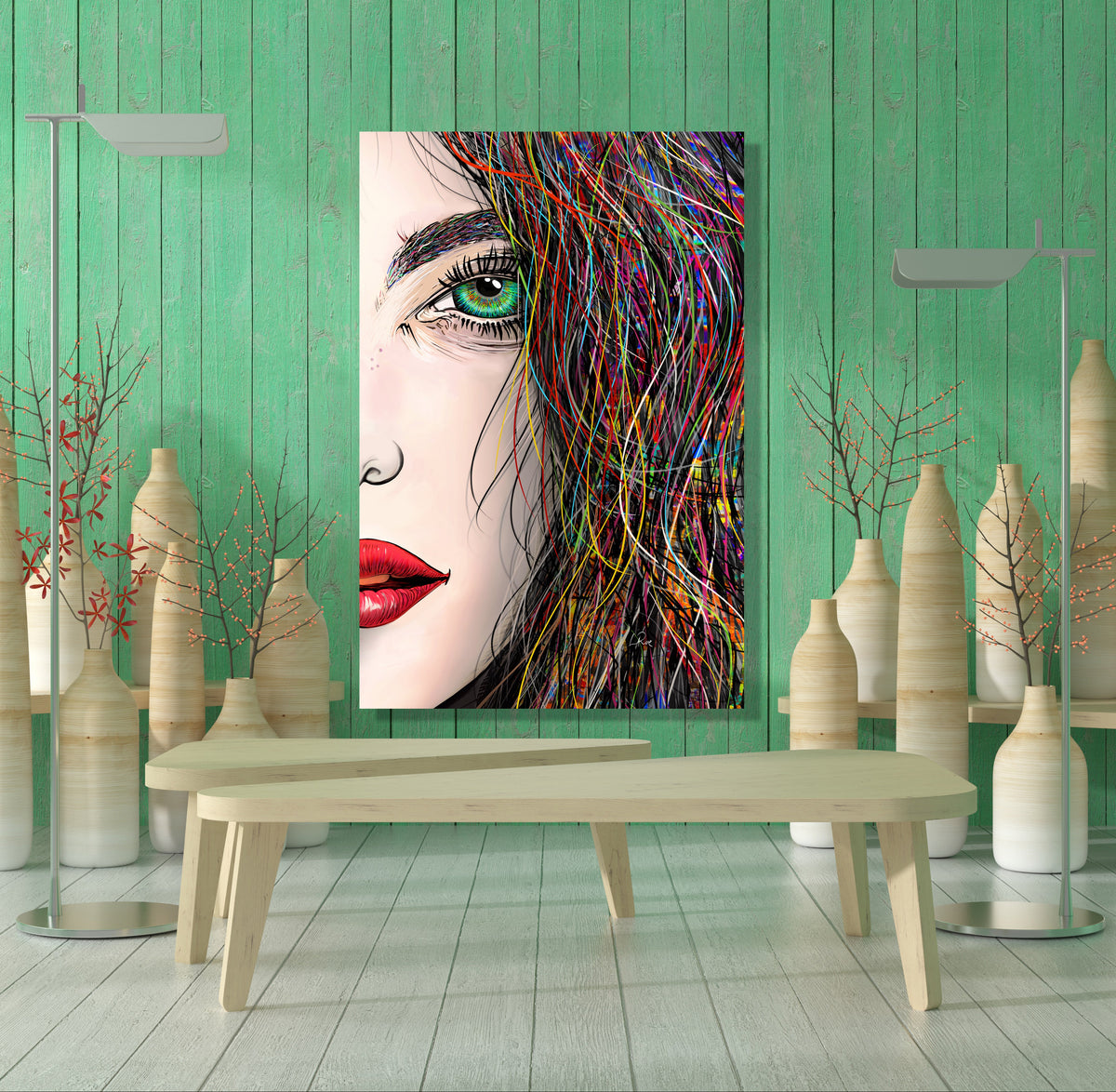 A vertical canvas art print featuring a stylized close-up portrait of a woman with green eyes, red lips, and colorful hair, displayed on a mint green wooden wall above a light wood bench in a modern styled room. Tara's Green Eye by our LaRue
