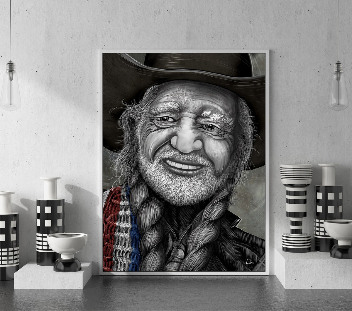 A framed black and white portrait print of a smiling man with a cowboy hat and braided hair, displayed on a shelf in a modern interior setting with decorative vases and pendant lights. Willie Nelson by Doug LaRue