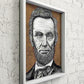 Ink portrait of President Abraham Lincoln on a white brick wall in a white woodl frame