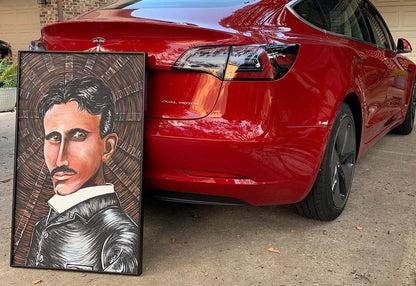 Nikola Tesla portrait painting by Doug LaRue in a black metal frame leaning against a red Tesla Model 3 car 